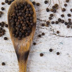 schwarzer Pfeffer auf einem Holzlöffel